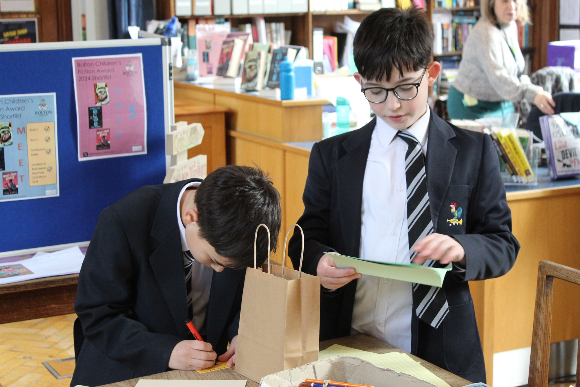 Two Bolton School Boys' Division pupils working on an activity on paper in the Library