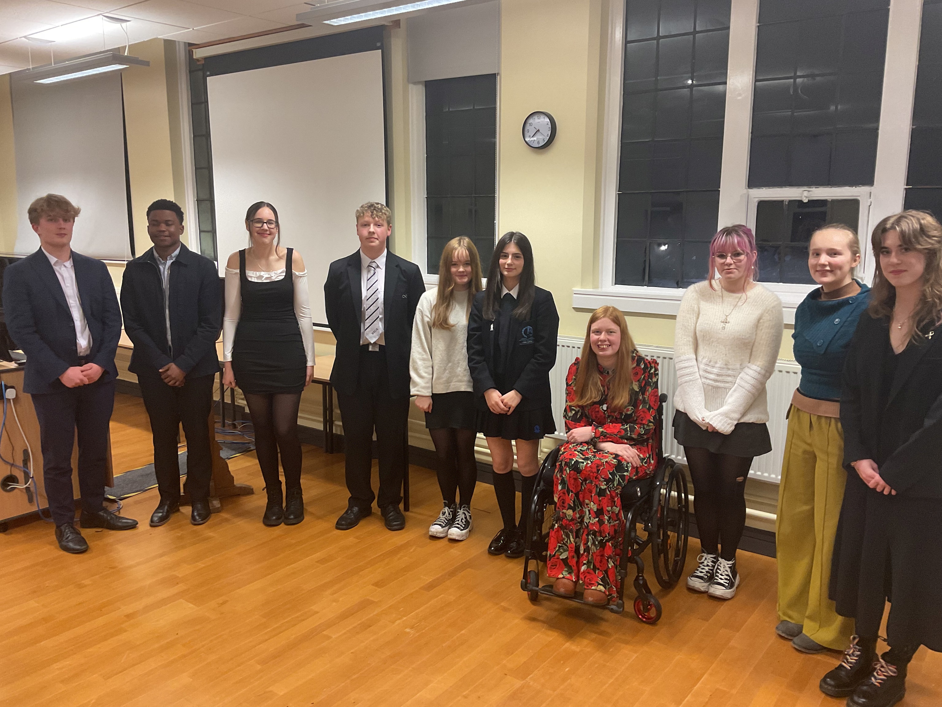 A line of 10 young people wearing a variety of smart outfits and school uniforms after taking part in the Great Debate competition